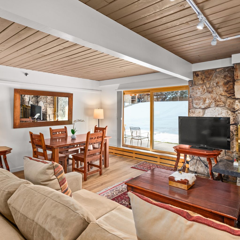 Stonebridge condo living and dining area with stone fireplace and mountain light